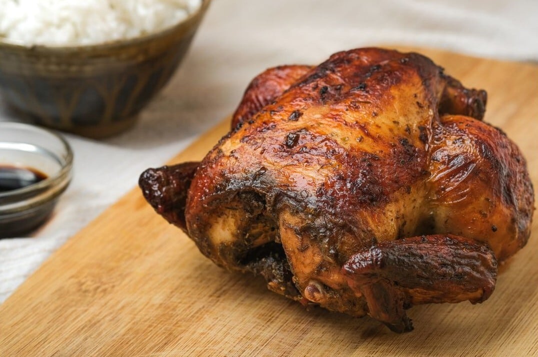 rotisserie chicken on wooden cutting board